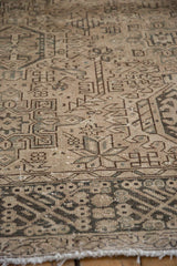 Distressed texture of a vintage Karaja rug, highlighting geometric patterns in pale coffee and olive.
