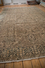 Distressed Karaja rug showing repeating hook and latch medallions in coffee brown and olive.