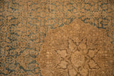 Detail of vintage distressed Bijar rug, showing mostly even wear, dusty teal pattern, and soft brown medallion.