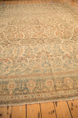 Angled view across the distressed pile and sprawling floral pattern of a vintage Lilihan carpet.