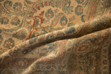 A fold in the vintage Lilihan carpet displays the low, even pile and muted floral pattern.