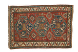 Antique Kazak rug with triple blue medallions on a red field featuring geometric motifs.