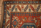 Antique Kazak rug border detail showing stylized pawn and animal motifs in blue, red and ivory.