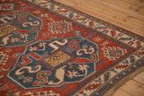 Bold sapphire blue medallion and geometric border detail on an antique hand-knotted Kazak rug.