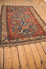 Short, hand-knotted fringe and secured selvage on an antique red and blue Caucasian Kazak rug.