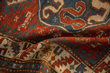 Mostly even wear and hand-knotted texture on a draped antique Kazak rug in red and blue.