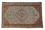 Antique distressed Malayer rug with a terracotta shield medallion on a platinum ground of floral vines.