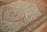 Angled corner view of an antique Malayer rug highlighting its even wear and intricate vine pattern.