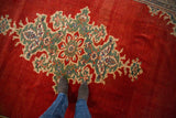Vintage Mahal carpet's starburst medallion showing jade green and ivory floral motifs on a cherry red field.