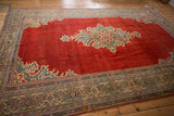 Angled perspective of a vintage Mahal carpet's abrashed red field and green spandrels.