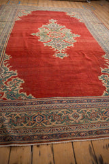 Angled perspective of the vintage Mahal carpet's abrashed red field, center medallion, and intricate borders.