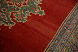 Abrashed cherry red field meeting the jade green spandrel and sapphire blue border of a vintage Mahal carpet.