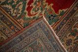 Folded corner of a vintage Mahal carpet showing the intricate turtle and vine boteh borders.