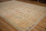 Angled view of the distressed vintage Tabriz showing its soft color palette and evenly worn low pile.