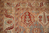 Pomegranate corner motif and serrated vine border on a distressed vintage Persian Bakhtiari carpet.