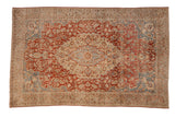 Vintage distressed Tabriz carpet with a concentric floral medallion, sprawling red vines, and slate blue spandrels on a sand field.