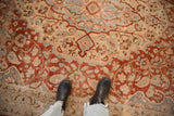 Detailed view of the distressed Tabriz carpet's even wear, showing red and slate blue floral patterns.