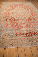 Softened cherry red and slate blue tones on the worn, low pile of a vintage Tabriz carpet.