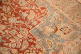 Palmette and arabesque border in slate blue, sand, and red on a distressed vintage Tabriz carpet.