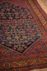 Navy blue corner spandrel and madder red vine border of a vintage Persian Malayer rug.