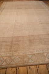 Angled view across the textured pile and geometric border of a distressed Kars rug.