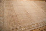 High-angle view of a vintage Kars carpet showing its distinct trellis panel and abrash-heavy sandy field.