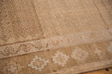Short, hand-knotted pile of a vintage Kars rug showing its sandy beige geometric border motifs.