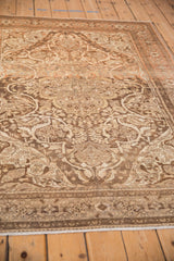 Angled view of the distressed pile showing sprawling arabesques in charcoal and terracotta.