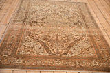 Angled perspective of a vintage Malayer rug highlighting its sprawling arabesques and distressed texture.