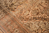 Angled view of the distressed texture and sprawling terracotta vines on a vintage Malayer rug.