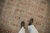 Overhead view of the distressed Mahal carpet showing soft wear over its dusty slate blue and mauve pattern.