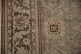 Worn-to-the-knot texture on the distressed Mahal carpet's floral border and slate blue field.