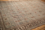Distressed vintage Mahal carpet showing rows of geometric guls on a time-softened, slate blue field.