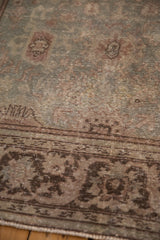 Detailed view of the vintage Mahal carpet's low-pile texture and sprawling chocolate brown floral border.