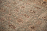 Detailed view of the distressed texture and mostly even wear on the slate blue and brown Mahal carpet.