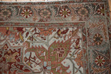 Detailed corner of a distressed Ahar carpet with pinwheel floral motifs and curvilinear vines.