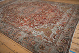 Angled view of the distressed Ahar carpet highlighting its abrashed texture and sprawling vine pattern.