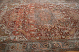 Angled view across the worn pile and intricate medallion of a vintage Ahar carpet.