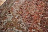 Sprawling vines and blossoms on the abrashed, chestnut rust pile of a vintage Ahar carpet.