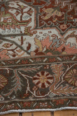 Close-up showing the pinwheel floral border and abrashed field of a vintage Ahar carpet.