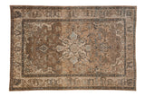 Distressed Isfahan rug with quatrefoil medallion, floral motifs, brown, beige, and blue tones.