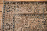 Detailed distressed texture of the vintage Isfahan rug, showing faded floral motifs and exposed foundation.