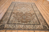 Distressed vintage Isfahan rug side with scrolling leaf border and worn pile texture.