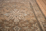 Distressed sand and brown Isfahan rug texture with powder blue floral motifs and visible foundation.