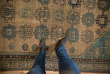 Antique Malayer carpet field featuring trident guls, beige lattice, dusty blue tones, and even wear.