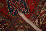 A folded corner of an antique Kazak rug showing the restored side cord and hand-knotted pile.