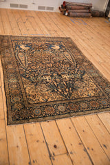 Angled view of the antique Farahan Sarouk rug's intricate tree-of-life pictorial design.