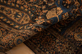 The dense, hand-knotted pile of an antique Farahan Sarouk in navy blue and dusty sandalwood.