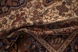 A draped vintage Malayer rug showing its time-softened short pile and arabesque pattern.