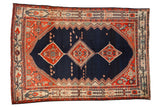 Vintage Persian Malayer carpet with a triple medallion on a navy blue field, framed by terracotta and ivory borders.